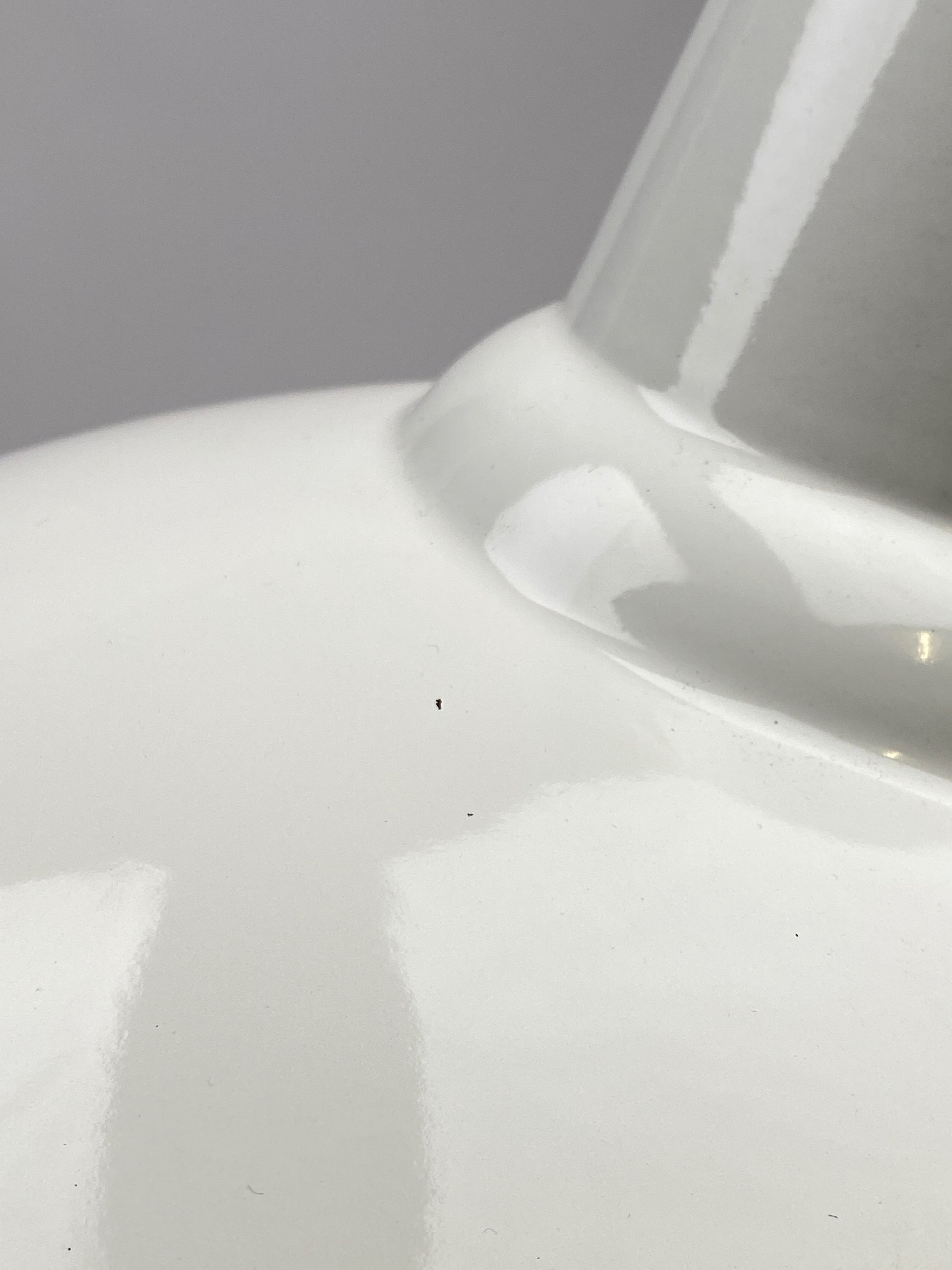 Example of Grade B damage that may be visible on a Worn Lighting Shade. Image shows minor chips/mark to the top of a white shade.